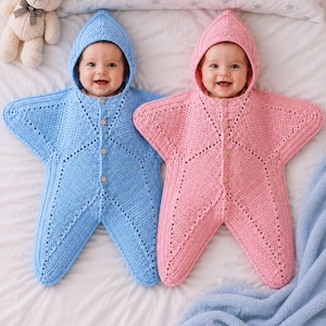 以下が含まれることがあります： フード付きの星型かぎ針編みおくるみを着た2人の乳児。1つはライトブルー、もう1つはライトピンクです。どちらの衣服も、小さな木製ボタンが付いた前開き、質感のあるニットパターン、星型の腕が特徴です。