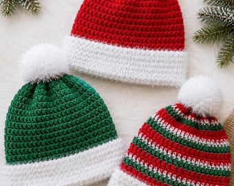 May include: Three crocheted beanies with white fuzzy pom-poms. One is solid red with a white brim, one is solid green with a white brim, and one features horizontal red, green, and white stripes with a white brim. All have a textured stitch.