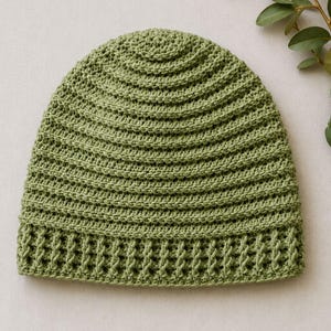 May include: A sage green crochet beanie featuring a textured ribbed stitch pattern throughout the main body and a distinct vertical post stitch design along the bottom edge, creating a structured and uniform appearance for this headwear piece.