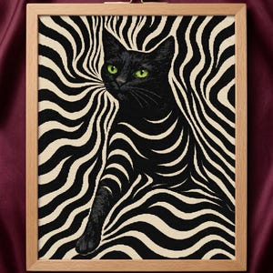 May include: Cross-stitch artwork in a wooden frame. The image depicts a black cat with green eyes set against a black and cream wavy pattern. The cat's paw is extended. The frame is made of light-coloured wood.