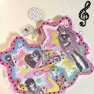 Könnte beinhalten: Eine rosa sternförmige Scrapbook-Seite mit Illustrationen im Anime-Stil und Noten. Die Seite enthält Text, einen Knopf mit der Aufschrift "CATS CATS CAT" und einen kleinen Schlüsselanhänger. Das Scrapbook ist mit Spitze und sternförmigen Akzenten verziert.