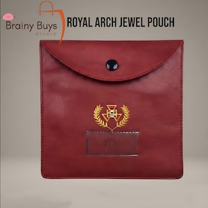 May include: A square, deep red jewel pouch with a flap closure secured by a single black button. The front features an embroidered gold emblem of a triangle surrounded by laurel leaves, positioned above a clear rectangular plastic name tag slot.