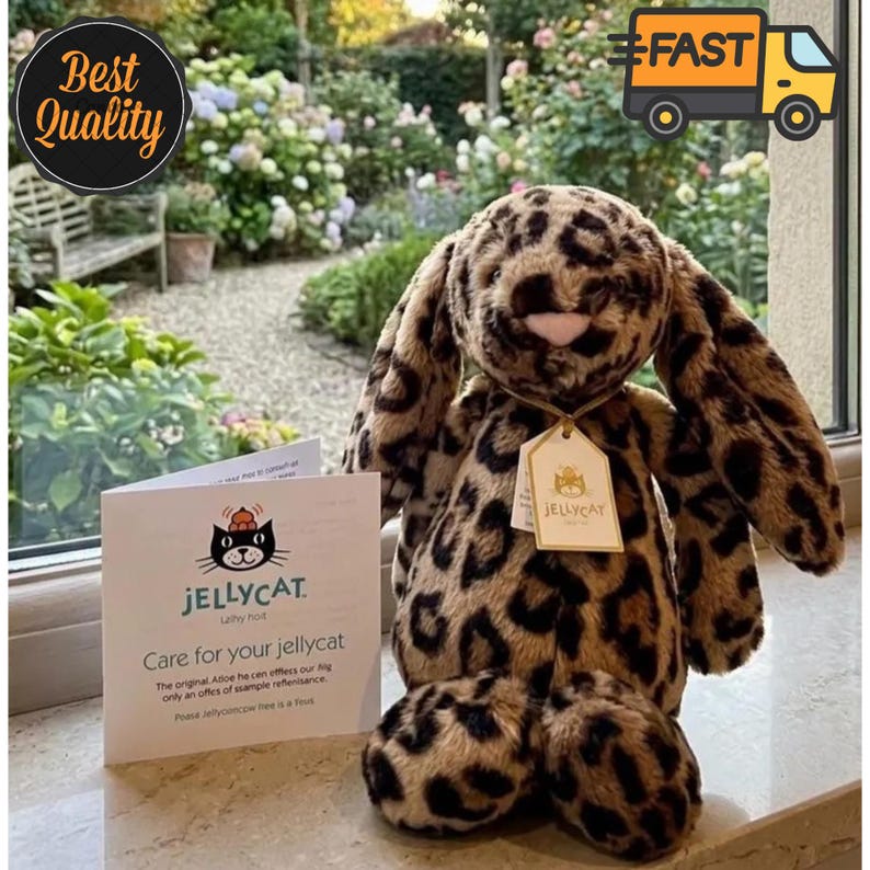 May include: A soft toy leopard-print bunny rabbit with long ears and a tag that reads "JELLYCAT." The bunny is next to a card that says "Care for your jellycat." The background includes a garden and the words "Best Quality" and "FAST."