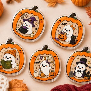 May include: Five circular acrylic charms featuring cute white ghosts inside orange pumpkins. The designs include a ghost with a witch hat and cauldron, a ghost with a pumpkin bucket and cat, a ghost reading a book, a ghost with a broom, and a vampire ghost.