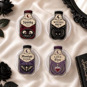 Op de afbeelding: Vier doorzichtige ronde onderzetters met flesvormige ontwerpen en labels met de teksten The Spooky Drink Okult, Witches Brew, Moonlight Potion en Love Elixir. Elke flesafbeelding bevat illustraties van schedels, een kat, een mot en een hart.