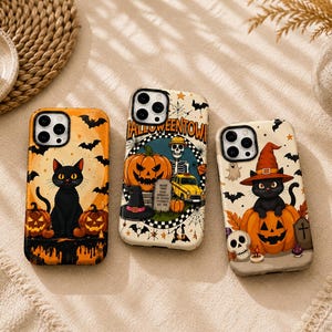 May include: Three smartphone cases featuring Halloween designs. The left case shows a black cat with orange pumpkins and bats. The center case displays a skeleton, pumpkin, and yellow car with the text HALLOWEENTOWN. The right case depicts a cat in a witch hat sitting on a pumpkin with a skull.