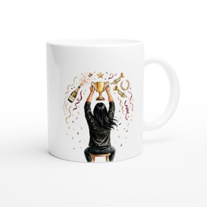 Può includere: Tazza in ceramica bianca con l'illustrazione di una persona che tiene in alto un trofeo d'oro. Il design include bottiglie di champagne, coriandoli, stelle, trombe e nastri, che celebrano una vittoria. La persona è seduta su uno sgabello.