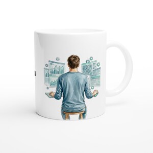 Puede incluir: Taza de cerámica blanca con una ilustración en acuarela de una persona frente a un ordenador, rodeada de gráficos y tablas de datos. La persona lleva una camisa azul y está sentada en un taburete. El diseño tiene detalles turquesa y grises.