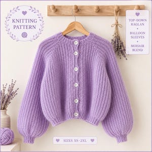 May include: A lilac mohair blend cardigan with balloon sleeves and a top-down raglan design. The button-down sweater features white buttons and is displayed on a wooden hanger. The image includes text that reads "Knitting Pattern" and "Sizes XS-2XL."