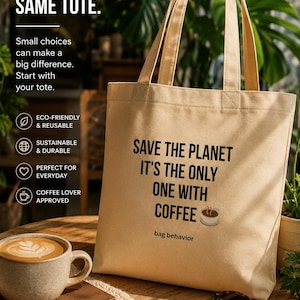 May include: A beige canvas tote bag featuring the black printed text: SAVE THE PLANET IT'S THE ONLY ONE WITH COFFEE, accompanied by a small coffee cup icon and the words bag behavior. The bag has two shoulder straps and a rectangular shape.