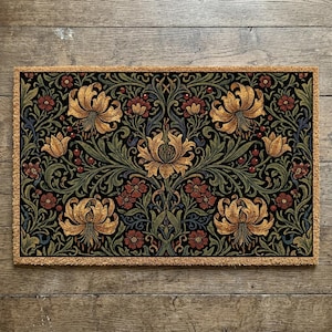 Può includere: Zerbino rettangolare con sfondo nero e un motivo floreale dettagliato. Il design presenta gigli dorati, fiori rossi e fogliame verde, il tutto incorniciato da un bordo marrone chiaro. Il motivo intricato aggiunge un tocco di eleganza.