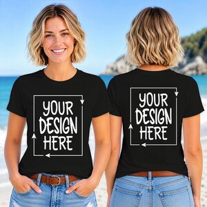 Puede incluir: Dos camisetas negras con el texto "YOUR DESIGN HERE" en un marco cuadrado blanco. Las camisetas las lleva una persona con vaqueros azules y un cinturón marrón. El fondo es una escena de playa con cielo azul y agua.