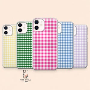Puede incluir: Cinco fundas para smartphone dispuestas en fila, cada una con un patrón de cuadros vichy distinto en amarillo, verde, rosa, azul y lavanda. Cada funda tiene un recorte para cámara dual y el logo de The Shell Lab está impreso debajo.