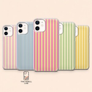 以下が含まれることがあります： ピンク、ブルー、グリーン、イエローなど、さまざまな色の縦縞模様の携帯電話ケースが5つ。ケースは透明で光沢があります。下部にはThe Shell Labのロゴがあります。