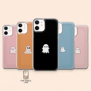 Può includere: Una collezione di custodie per telefoni in vari colori, tra cui rosa, arancione, nero e blu. Ogni custodia presenta una grafica di un fantasma bianco. Il logo The Shell Lab è visibile.