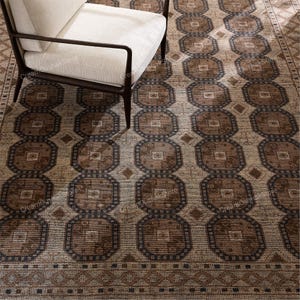 Peut inclure: Tapis à motifs avec un motif géométrique dans les tons marron, beige et bleu marine. Le tapis présente un motif octogonal répétitif et un motif de bordure. Un fauteuil blanc avec des pieds marron foncé est partiellement visible.