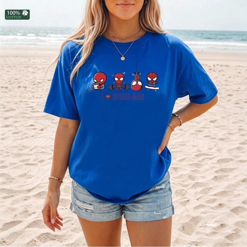 May include: A royal blue short-sleeve t-shirt featuring a graphic print of four small Spider-Man characters performing different activities, including eating, lifting weights, hanging, and skateboarding, with the text I heart SPIDER-MAN.