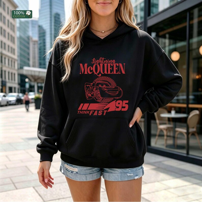 Pu&ograve; includere: Felpa con cappuccio nera con grafica rossa di Saetta McQueen del film Cars. La grafica include il testo "Lightning McQueen", "95" e "Think Fast". La felpa &egrave; realizzata in 100% cotone.