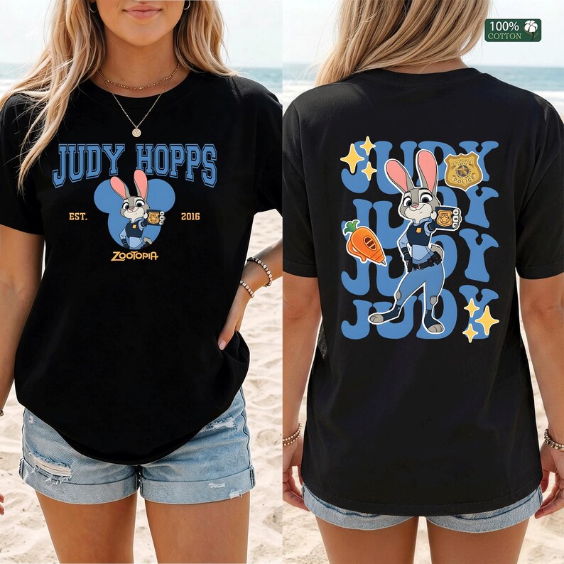 Pu&ograve; includere: Una t-shirt nera con una grafica di Judy Hopps di Zootropolis. Il davanti mostra il testo Judy Hopps, Est. 2016 e Zootopia. Il retro mostra Judy Hopps, una carota, un distintivo della polizia e il testo Judy ripetuto in carattere blu.