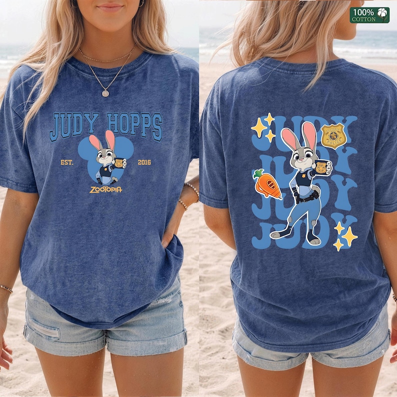 Pu&ograve; includere: Una t-shirt blu con effetto lavaggio acido raffigurante Judy Hopps di Zootropolis. Il davanti mostra il testo Judy Hopps Est. 2016 con un grafico del personaggio. Il retro presenta una grande illustrazione di Judy Hopps, una carota e testo.