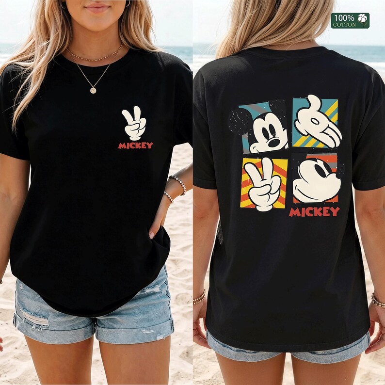 May include: Black t-shirt featuring a Mickey Mouse design. The front displays a peace sign hand gesture and the word "Mickey" in red. The back showcases four Mickey Mouse images in colorful squares, with the word "Mickey" at the bottom.