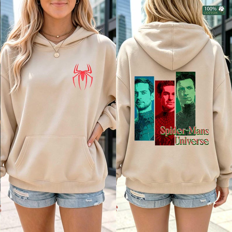 May include: A beige hooded sweatshirt featuring a red spider emblem on the front chest. The back displays three vertical rectangular portraits of men in superhero suits, colored blue, red, and green, with the text Spider-Mans Universe below.