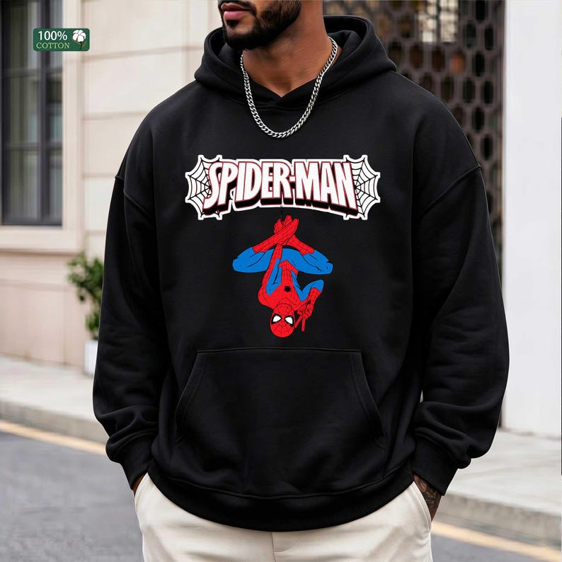 May include: Black hooded sweatshirt with a Spider-Man design. The graphic shows the Spider-Man logo in white with red text and a red and blue Spider-Man figure. The sweatshirt is made of 100% cotton.
