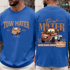 May include: A royal blue t-shirt featuring a graphic of the character Tow Mater. The front displays the text TOW MATER EST. 2006 CARS with a small truck illustration. The back features a larger truck graphic with the text TOW MATER ANYTIME ANYWHRE ANYPLACE.