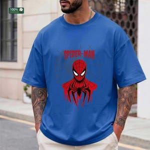 May include: Blue t-shirt featuring a red and black Spider-Man graphic. The design includes the words "SPIDER-MAN" in red above the character's head. The shirt is made of 100% cotton.