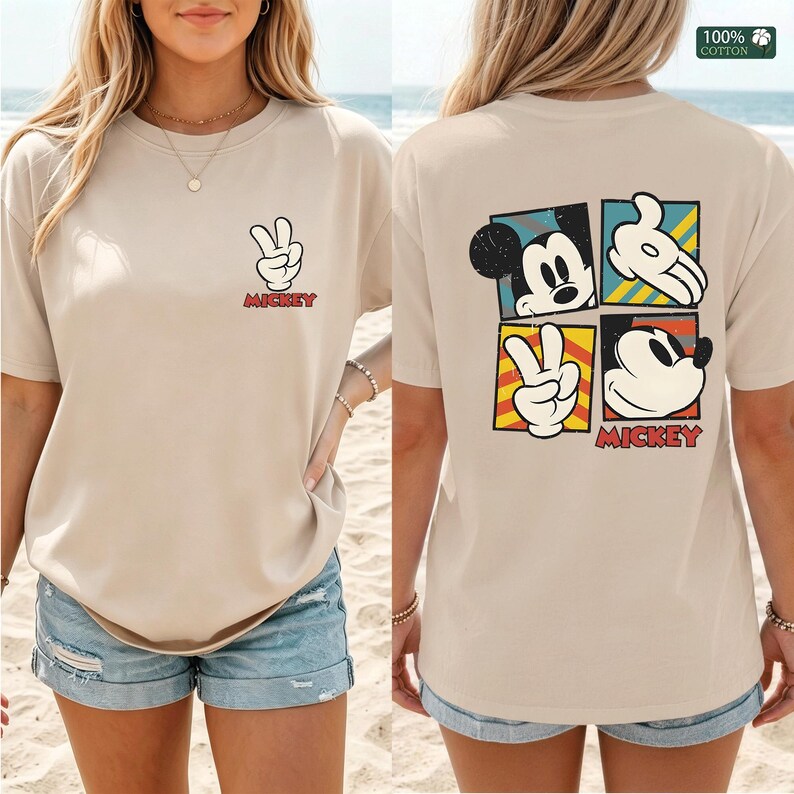 May include: Beige t-shirt featuring a Mickey Mouse peace sign graphic on the front and a four-panel design on the back. The back design includes Mickey's face, hands, and peace sign, with the word "Mickey" in red.
