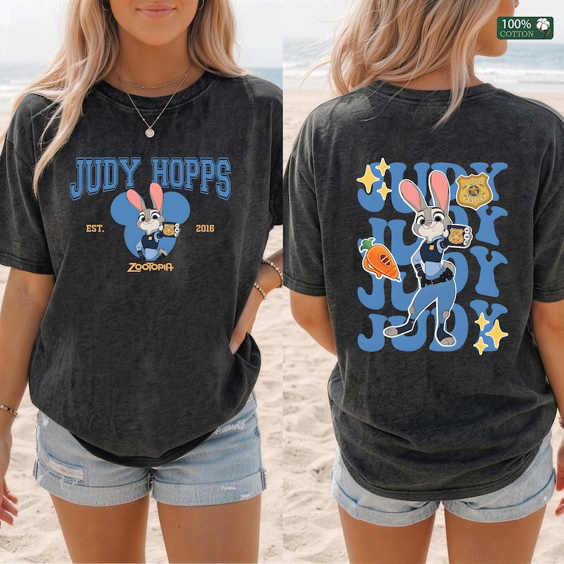 Pu&ograve; includere: Una t-shirt a maniche corte grigio antracite con Judy Hopps di Zootropolis. Il davanti mostra il testo Judy Hopps, Est. 2016 e un grafico del personaggio. Il retro presenta una grande grafica di Judy Hopps, una carota, un distintivo e stelle.