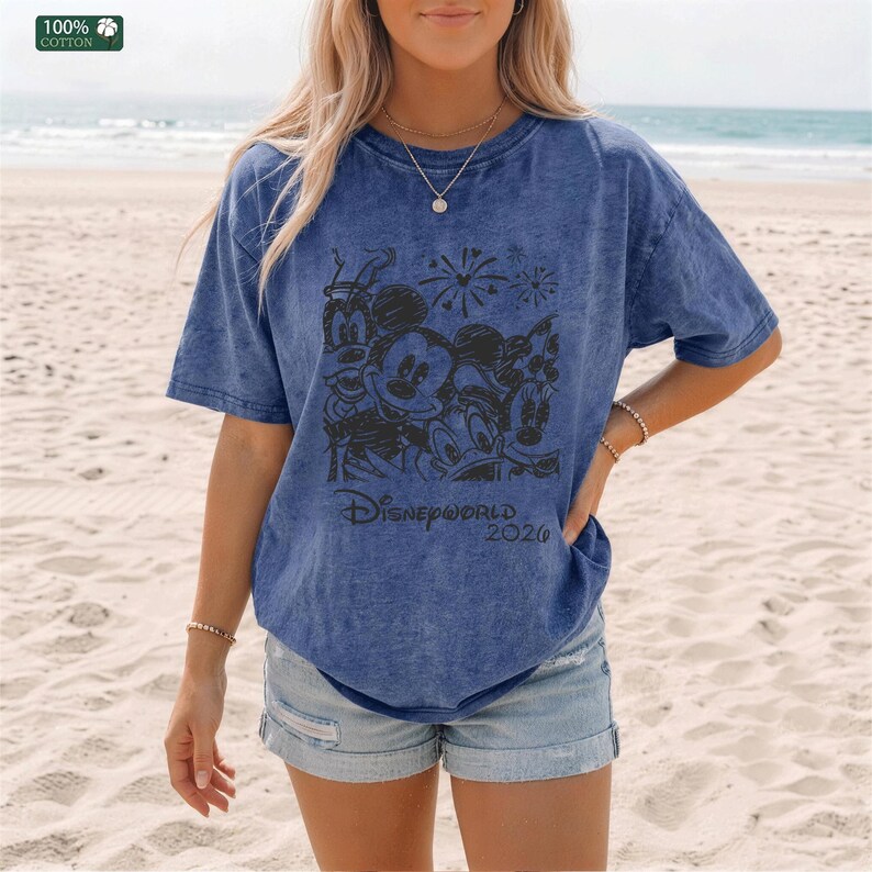 Puede incluir: Camiseta azul con un gr&aacute;fico de personajes de Disney, incluyendo Mickey Mouse, Donald Duck y Goofy. El texto "Disneyworld 2020" est&aacute; impreso debajo. La camiseta es 100% algod&oacute;n.