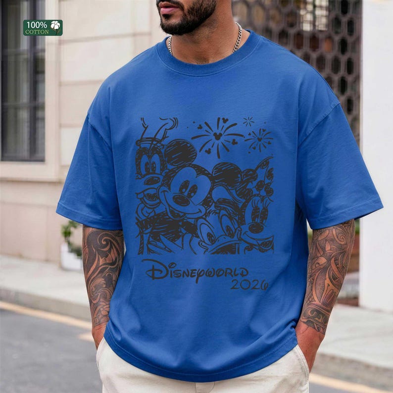 Puede incluir: Camiseta azul con un dise&ntilde;o negro de Mickey, Minnie, Donald y Goofy. El texto "Disneyworld 2020" est&aacute; impreso debajo. La camiseta es 100% algod&oacute;n.