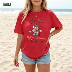Op de afbeelding: Rood T-shirt met een cartoonillustratie van een aardappelpersonage in een gezocht poster. De tekst op het shirt luidt "Wanted" en "$50 Billion Reward". Gemaakt van 100% katoen.