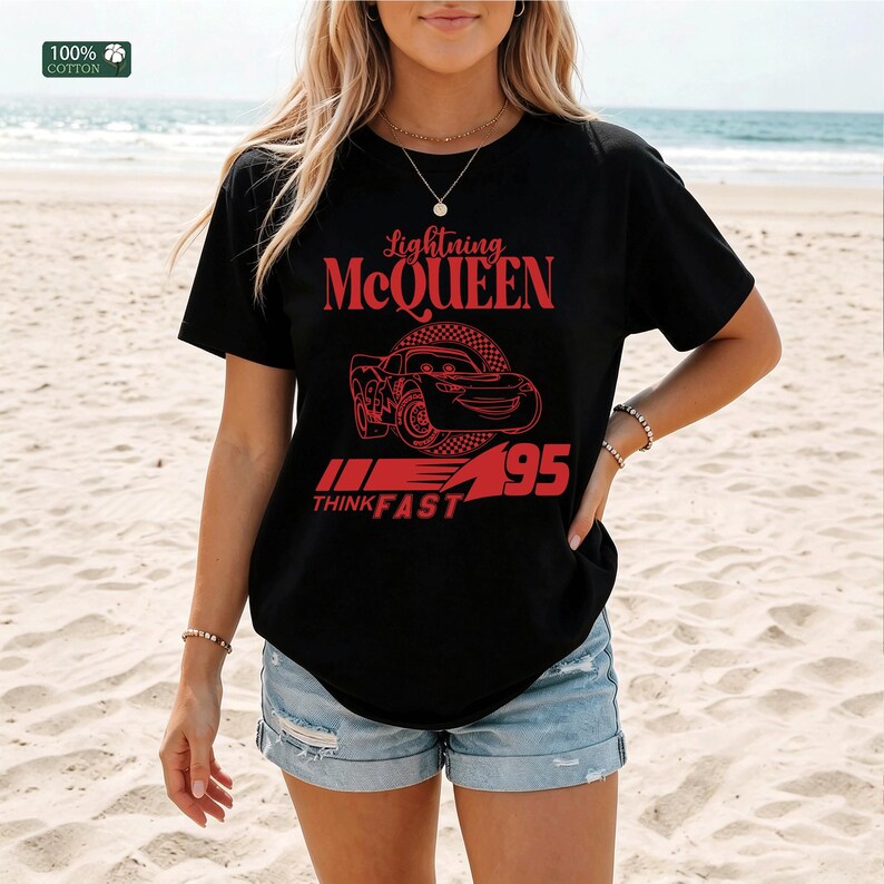 Pu&ograve; includere: T-shirt nero con grafica rossa di Saetta McQueen del film Cars. Il design include il testo "Lightning McQueen", un'illustrazione di auto, il numero "95" e la frase "Think Fast". La maglietta &egrave; realizzata in 100% cotone.