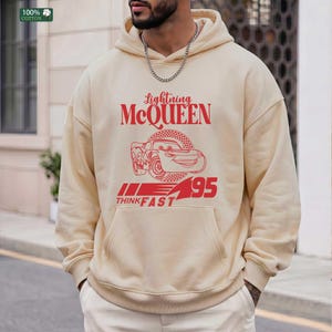 Pu&ograve; includere: Felpa con cappuccio color crema con grafica rossa di Saetta McQueen del film Cars. Il testo "Lightning McQueen" &egrave; sopra l'auto e "95 THINK FAST" sotto. La felpa ha una tasca frontale e un cappuccio con coulisse.
