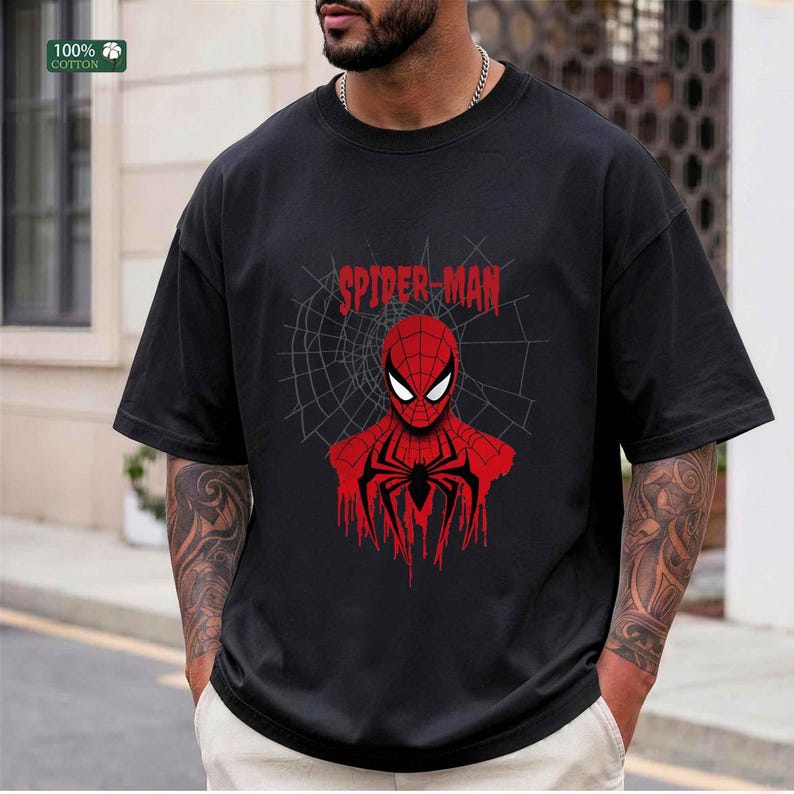 May include: Black t-shirt featuring a red and black Spider-Man graphic. The design includes the words "Spider-Man" above the character's face and a spider web background. Made of 100% cotton.