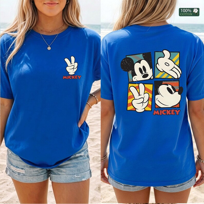 May include: Royal blue t-shirt featuring a Mickey Mouse peace sign graphic on the front and a four-panel design on the back. The back design includes Mickey's face, hands, and the word "Mickey" in red.