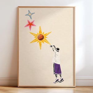 May include: A framed wall art print on a light beige background featuring a basketball player in a white shirt and purple shorts shooting a basketball towards a large yellow star. Above the yellow star are a pink star and a light blue star.