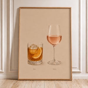 Op de afbeelding: Een ingelijste kunstprint op een beige achtergrond met een glas amberkleurige vloeistof met een ijsblokje en een schijfje sinaasappel met het label 'his.' naast een glas op voet met roze vloeistof met het label 'hers.' in een serif lettertype.