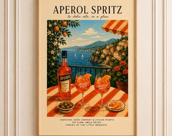 May include: A framed vintage-style poster featuring an Aperol Spritz advertisement. The image showcases a bottle of Aperol, two cocktails, and olives on a table with a coastal Italian backdrop. Text includes "APEROL SPRITZ" and "la dolce vita, in a glass."
