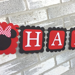May include: A celebratory banner with red and black scalloped edges. The banner reads "HAPPY 2nd" in white letters on red squares. A Minnie Mouse head with a polka dot bow is on the left.