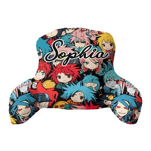 May include: A T-shaped reading pillow featuring a vibrant, multi-coloured anime-style character print with red, blue, pink, and yellow hair. The name Sophia is printed in a large, white, cursive script across the centre of the pillow surface.