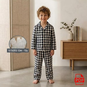 Peut inclure: Un enfant porte un pyjama à carreaux noirs et blancs. L'ensemble comprend une chemise à manches longues et un pantalon. Le texte de l'image indique "13 SIZES 12m - 12y".
