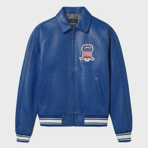 May include: A vibrant blue leather jacket with a classic collar and a zip-up front. Features a patch on the chest with an American flag design and the brand name. The cuffs and hem have white stripes.