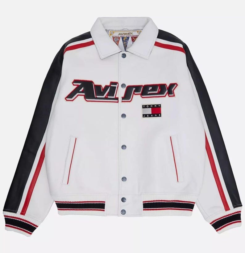 May include: White leather jacket with black sleeves and red detailing. The jacket features the "Avirex" logo in red and black, and a "Tommy Jeans" patch. It has a button-up front and striped detailing on the cuffs and hem.