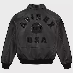 May include: Black leather jacket with the word "AVIREX" arched across the back, above a circular emblem and the word "USA". The jacket has a collar, a black ribbed hem, and cuffs.