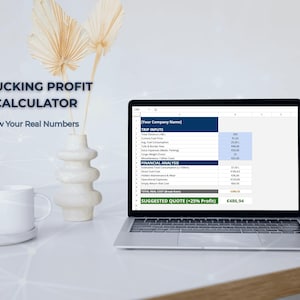 May include: A laptop displaying a trucking profit calculator spreadsheet. The screen shows financial data with the text "TRUCKING PROFIT CALCULATOR" and "Know Your Real Numbers". A white mug and decorative vase are on the table.
