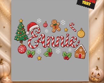 May include: A DTF transfer design featuring the name Annie written in a red and white candy cane font. The graphic includes a Christmas tree, a gingerbread person, a gingerbread house, holly berries, snowflakes, and ornaments on a gray background.