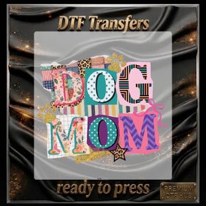 May include: A vibrant DTF transfer design featuring the text "DOG MOM" in a patchwork style. The design incorporates floral, polka dot, and chevron patterns, complemented by gold glitter accents and paw prints. The words "ready to press" are also displayed.